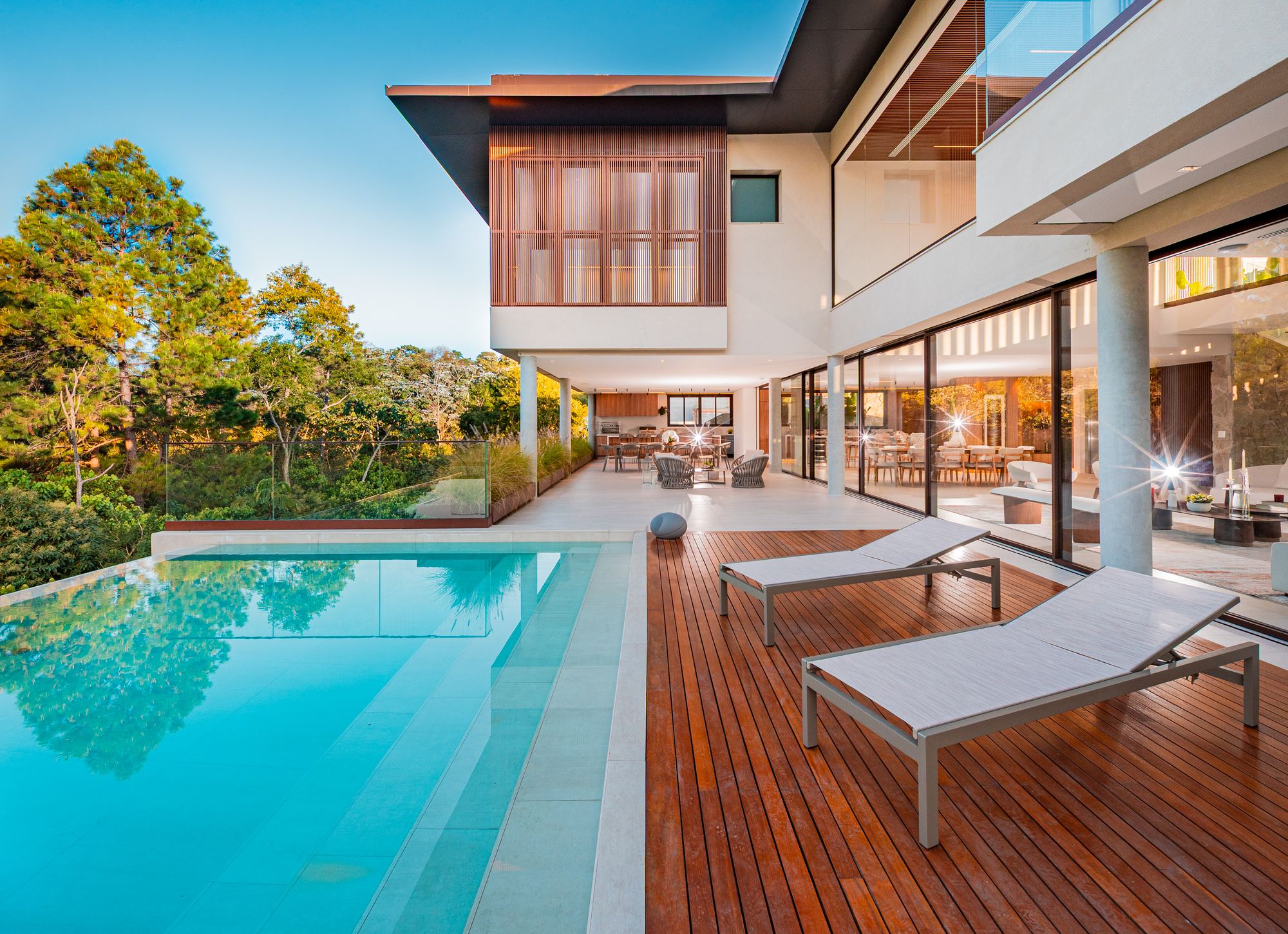 Piscina de borda infinita e deck de madeira em casa de alto padrão na Granja Vianna